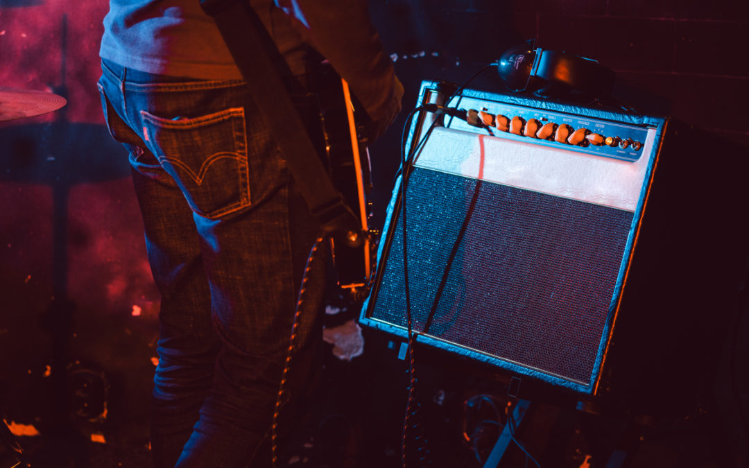 Guitar player in front of amplifier playing music